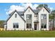 Charming two-story home with white brick, black trim, lush lawn, and professionally landscaped yard at 3735 Tamiami Trl, Cumming, GA 30041