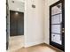 Light-filled foyer with hardwood floors, black door, and decorative wall paneling at 3735 Tamiami Trl, Cumming, GA 30041