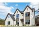 Elegant two-story home with brick and gray trim, featuring large windows and well-manicured landscaping at 3735 Tamiami Trl, Cumming, GA 30041