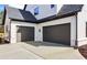 Two-car garage with dark-colored doors and modern design elements on the exterior at 3735 Tamiami Trl, Cumming, GA 30041