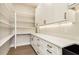 Walk-in pantry with white cabinets, drawers, and open shelves for organized storage at 3735 Tamiami Trl, Cumming, GA 30041