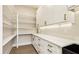 Walk-in pantry with white cabinets, drawers, and open shelves for organized storage at 3735 Tamiami Trl, Cumming, GA 30041