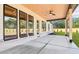 Covered patio with wood ceiling, ceiling fan, and large windows overlooking the backyard at 3735 Tamiami Trl, Cumming, GA 30041