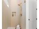 Tiled shower with gold hardware, recessed niche, and glass doors at 3735 Tamiami Trl, Cumming, GA 30041