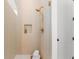 Modern shower with neutral tiles, gold fixtures, and built-in niche for bath products at 3735 Tamiami Trl, Cumming, GA 30041