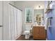 Bathroom with a vanity, toilet, shower with a white curtain and a view to the exterior at 6160 Oriole Ln, Cumming, GA 30028