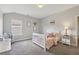 Bedroom featuring a crib, soft carpet, natural light, and neutral colors at 6160 Oriole Ln, Cumming, GA 30028