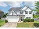 Traditional home with white siding, complemented by a green lawn, and a two-car garage at 6160 Oriole Ln, Cumming, GA 30028