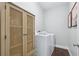 Laundry room featuring a cabinet, washer and dryer, and hardwood floors at 6160 Oriole Ln, Cumming, GA 30028