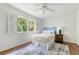 Bright bedroom with wood floors, ceiling fan, and large window overlooking trees at 6960 Hunters Branch Dr, Atlanta, GA 30328