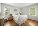 Cozy bedroom with hardwood floors, two bright windows, and a comfortable bed with white bedding at 6960 Hunters Branch Dr, Atlanta, GA 30328