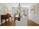 Bright dining room boasts hardwood floors, stylish lighting, and large windows overlooking the yard at 6960 Hunters Branch Dr, Atlanta, GA 30328