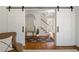 Open foyer with barn doors, wood floors, console table, arched mirror and view of the stairway at 6960 Hunters Branch Dr, Atlanta, GA 30328
