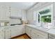 Bright kitchen featuring white cabinets, modern appliances, and a greenhouse window at 6960 Hunters Branch Dr, Atlanta, GA 30328