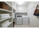 Well-organized laundry room with shelving, washer, dryer, and storage space at 6960 Hunters Branch Dr, Atlanta, GA 30328