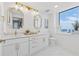 Modern bathroom featuring dual sinks, marble countertops, and a bright window at 75 14Th Ne St # 3820, Atlanta, GA 30309