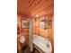 Rustic bathroom featuring wood paneling, a clawfoot tub, and unique fixtures at 835 Timber Lake Trl, Cumming, GA 30041