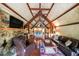 Inviting living room featuring exposed beams, a stone fireplace, and stylish furnishings at 835 Timber Lake Trl, Cumming, GA 30041