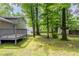 View of a spacious backyard from the deck, showing lush lawn, mature trees, and a storage shed at 3110 Ashly Cove Ln, Snellville, GA 30078