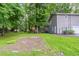 View of the level backyard featuring a partially fenced yard, mature trees, and well maintained lawn at 3110 Ashly Cove Ln, Snellville, GA 30078