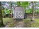 Backyard with a barn-style storage shed painted neutral with white trim and double doors with a wooden ramp at 3110 Ashly Cove Ln, Snellville, GA 30078