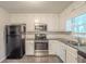 Well-lit kitchen featuring stainless steel appliances, granite countertops, and white cabinets at 3110 Ashly Cove Ln, Snellville, GA 30078