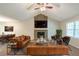 Comfortable living room with a stone fireplace, vaulted ceilings, leather furniture, and a ceiling fan at 3110 Ashly Cove Ln, Snellville, GA 30078