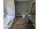 Bathroom with tub, gray vanity and granite countertops, and light wood-look floors at 563 Fieldgreen Dr, Jonesboro, GA 30238