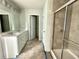 Well-lit bathroom with a double vanity, a glass-enclosed shower, and modern fixtures at 1654 Tide Mill Rd, Cumming, GA 30040