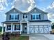 Charming two-story home featuring a two-car garage, inviting porch, and beautifully designed front facade at 1654 Tide Mill Rd, Cumming, GA 30040