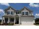 Charming two-story home featuring a covered porch, gray siding and a two car garage at 1654 Tide Mill Rd, Cumming, GA 30040