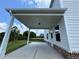 Covered patio with white posts and brick trim, leading to a spacious backyard at 1654 Tide Mill Rd, Cumming, GA 30040