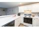 Well-lit kitchen with white cabinets, appliances, and a view of the adjacent living space at 183 Venture Path, Hiram, GA 30141