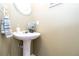 Charming powder room with pedestal sink, round mirror, and decorative hand towel at 183 Venture Path, Hiram, GA 30141