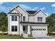 Charming two-story home with a brick foundation, light gray siding, and a two-car garage at 202 Wild Ginger Bnd, Woodstock, GA 30188