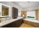 Bright bathroom with double vanity, soaking tub and tan tile surround at 4569 Fountain Ne Dr, Marietta, GA 30067