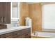 Bright bathroom featuring a vanity and tiled soaking tub near the window at 4569 Fountain Ne Dr, Marietta, GA 30067