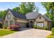 Inviting home with well-maintained lawn, mature trees, an attached garage, and a charming stone and stucco facade at 4569 Fountain Ne Dr, Marietta, GA 30067