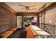 Enclosed outdoor dining area with wood paneled walls, a long table with benches, and a ceiling fan at 4569 Fountain Ne Dr, Marietta, GA 30067