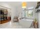 Luxurious primary bathroom features soaking tub, natural light, stylish fixtures, and walk-in closet at 1181 Fairview Ne Rd, Atlanta, GA 30306