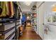 Organized walk-in closet featuring custom shelving, drawers, wood floors, and an adjacent luxury bathroom at 1181 Fairview Ne Rd, Atlanta, GA 30306