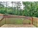 A view from the wooden deck to the flat, grassy backyard with wood fence and mature trees at 200 Mona Ct, Lawrenceville, GA 30044