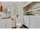 Laundry room with sink, modern washer and dryer, and natural light at 2896 Tiffany Cir, Lawrenceville, GA 30044