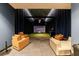 A modern entertainment room features theater-style seating and a golf simulator for recreation at 2425 Peachtree Rd # 1806, Atlanta, GA 30305