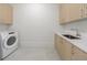 Well-lit laundry room with modern washer, sink, and plenty of cabinet space at 2425 Peachtree Rd # 1806, Atlanta, GA 30305
