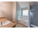 Bright bathroom featuring a soaking tub with tiled backsplash, a glass-door shower, and a neutral-toned vanity at 260 Redding Rdg, Atlanta, GA 30349