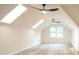 Attic with two skylights, a window and two modern black ceiling fans provides natural light to the room at 300 Saddle Creek Ln, Roswell, GA 30076