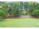Large, grassy backyard with a wooden privacy fence, offering ample space for recreation and relaxation at 300 Saddle Creek Ln, Roswell, GA 30076