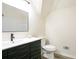 Modern bathroom features a dark vanity with a black faucet, a large mirror, a white toilet and white tiled shower at 300 Saddle Creek Ln, Roswell, GA 30076