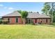 Charming brick home featuring a well-manicured lawn and a striking red front door at 300 Saddle Creek Ln, Roswell, GA 30076